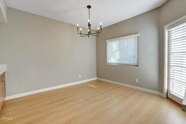 en empty room with windows and chandelier