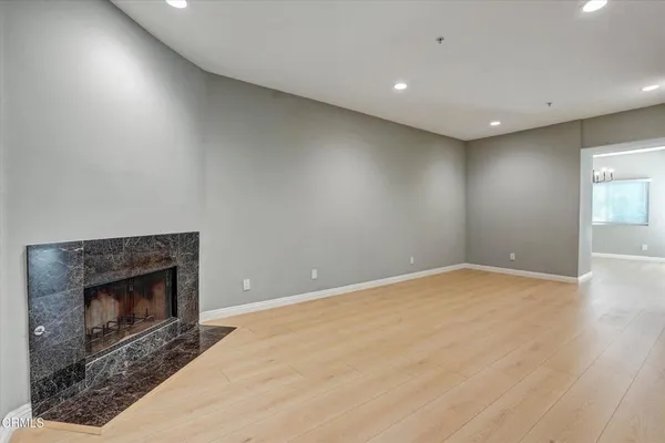 a view of empty room with wooden floor and fireplace