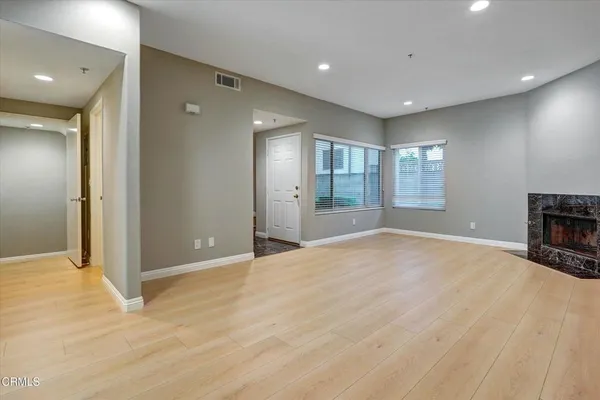 a view of empty room with wooden floor and fireplace