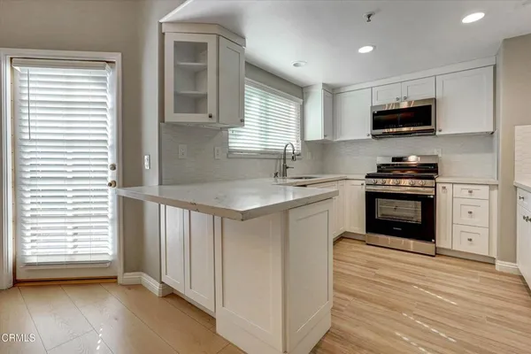 a kitchen with granite countertop a sink stainless steel appliances and cabinets