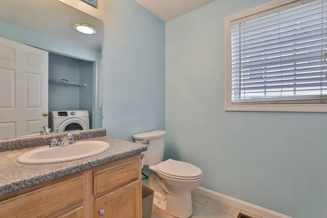 a bathroom with a granite countertop sink toilet and a mirror