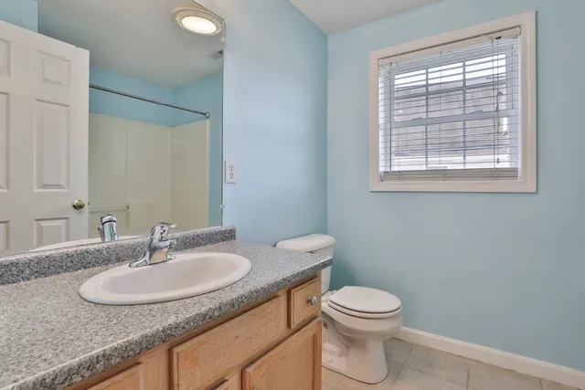 a bathroom with a granite countertop sink a toilet and a mirror