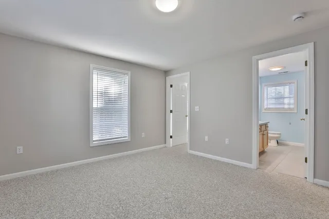 an empty room with windows and bathroom view