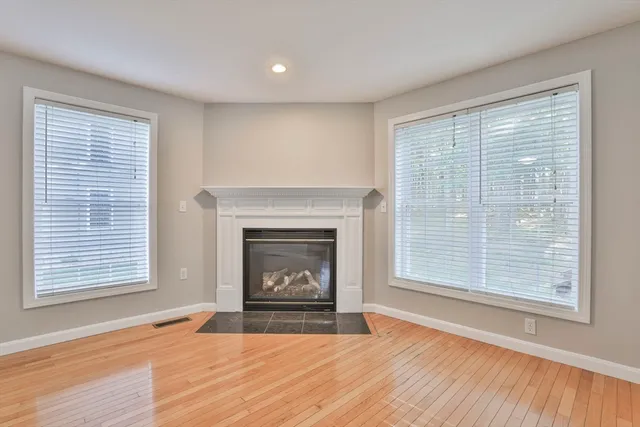 a view of an empty room with a window and fire place