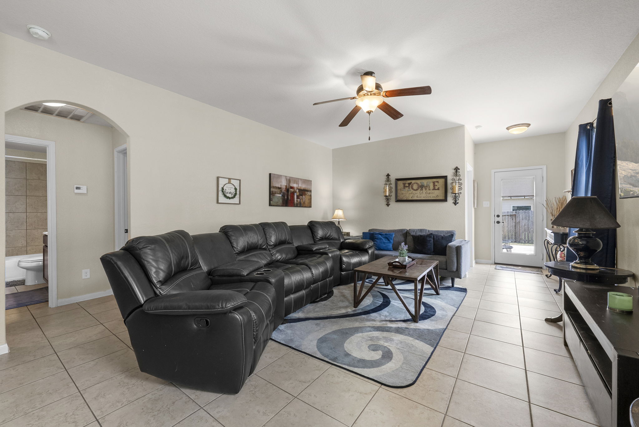 1617 Treeta Trail Kyle, TX 78640 - Photo 25 of 39 Living room featuring arched walkways, a ceiling fan, and light tile patterned flooring