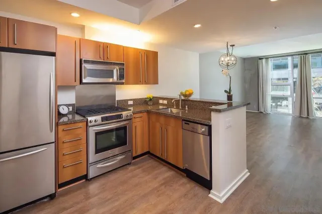 a kitchen with stainless steel appliances a stove a sink a refrigerator and cabinets