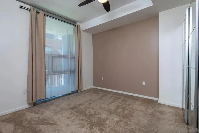 an empty room with closet and a chandelier fan