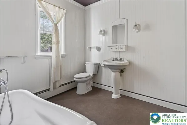 a bathroom with a bathtub and next to a window