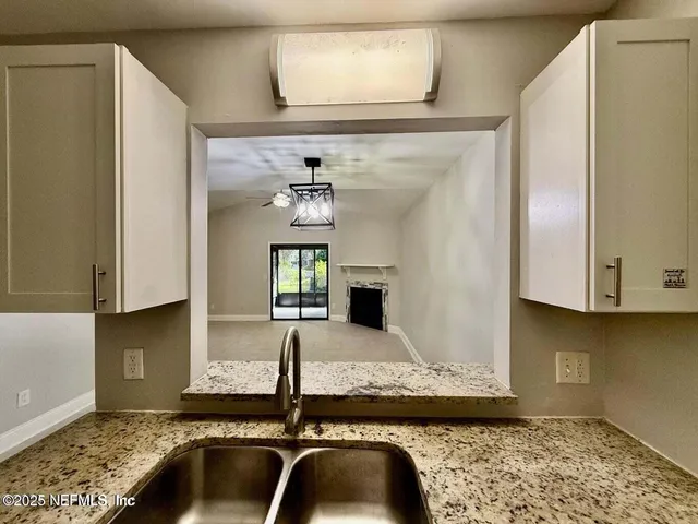 a kitchen with a granite countertop sink and a stove top oven