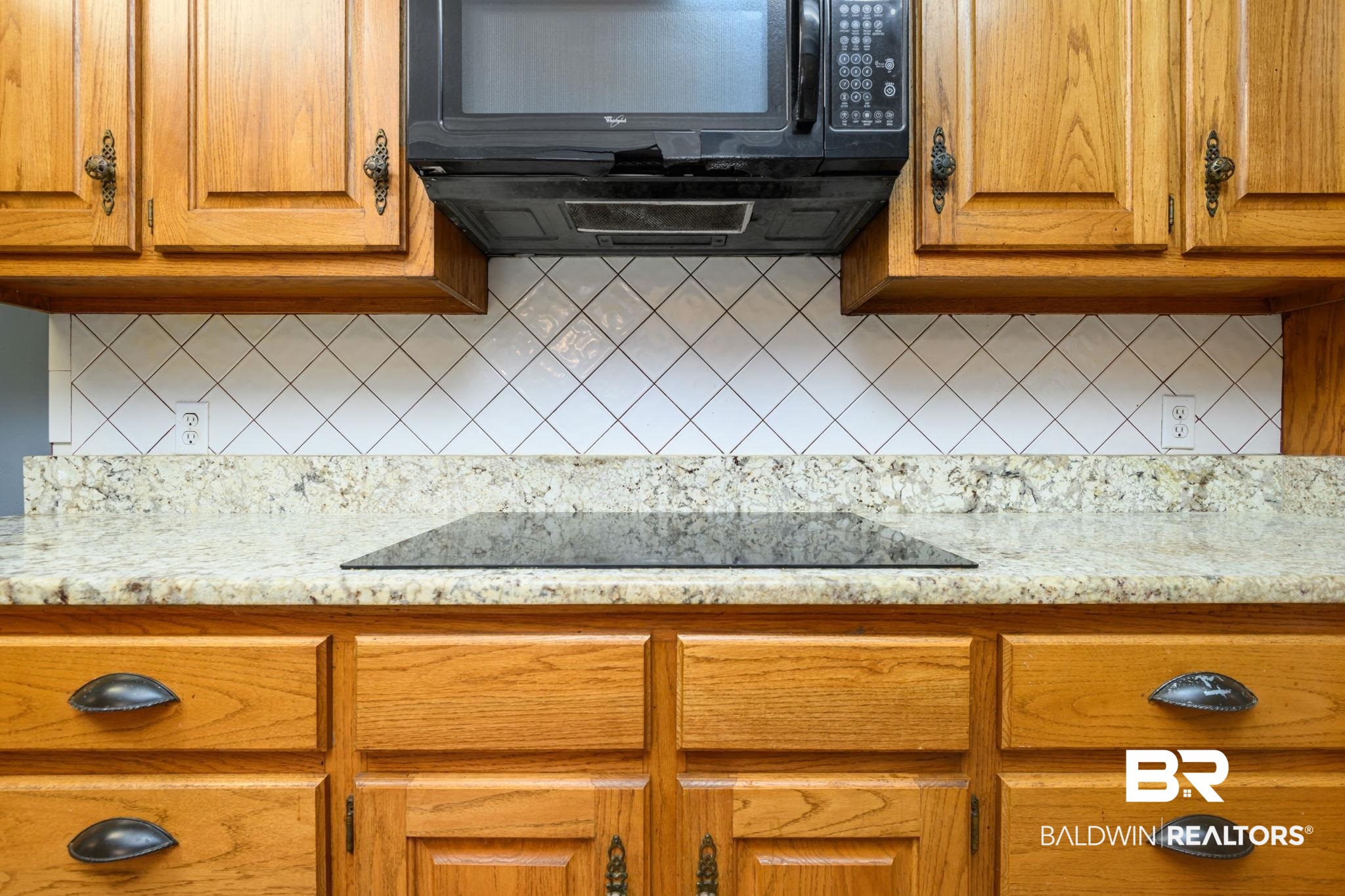 7540 2 Mile Road Irvington, AL 36544 - Photo 22 of 82 Kitchen workspace featuring wood cabinetry, a granite-finish countertop, a built-in cooktop, and a white diagonal tile backsplash