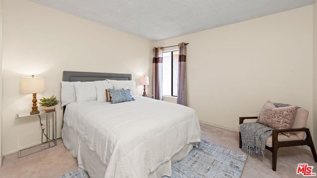 a bedroom with a bed chair and window