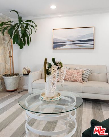a living room with furniture flowerpot and wooden floor