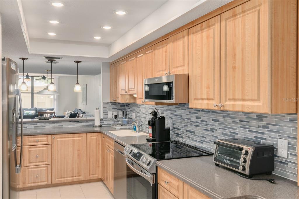 8701 Midnight Pass Road, Unit 106A Sarasota, FL 34242 - Photo 14 of 54 a kitchen with stainless steel appliances granite countertop a sink a stove and cabinets