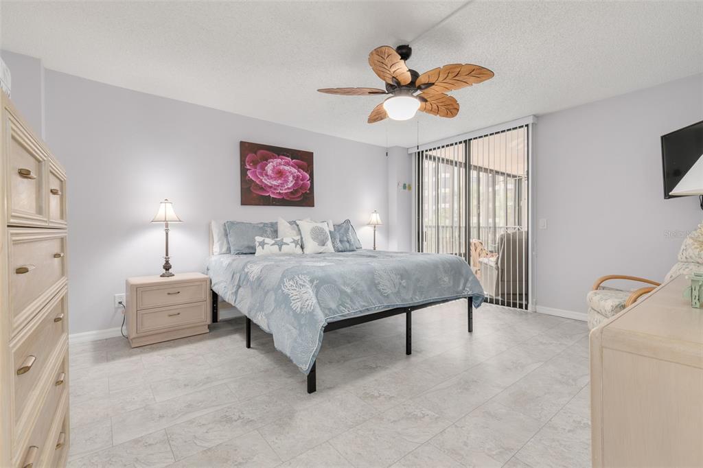 8701 Midnight Pass Road, Unit 106A Sarasota, FL 34242 - Photo 23 of 54 a bedroom with a bed and a chandelier