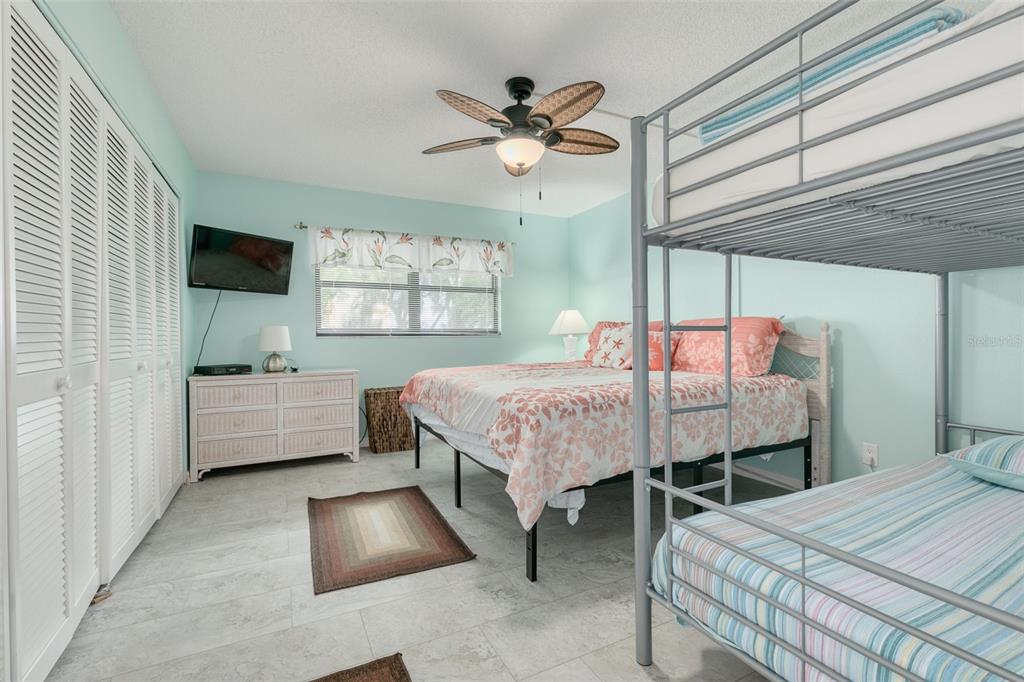 8701 Midnight Pass Road, Unit 106A Sarasota, FL 34242 - Photo 28 of 54 a bedroom with a bed and a chandelier