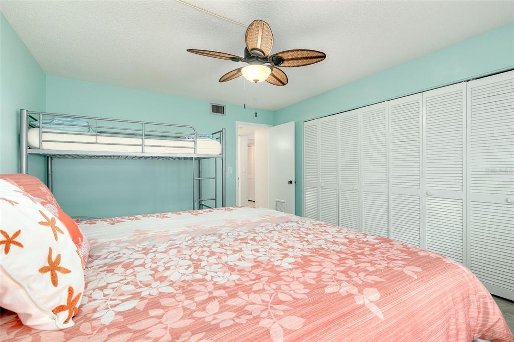 8701 Midnight Pass Road, Unit 106A Sarasota, FL 34242 - Photo 29 of 54 a bedroom with a large bed and a chandelier