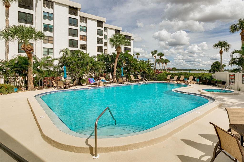 8701 Midnight Pass Road, Unit 106A Sarasota, FL 34242 - Photo 34 of 54 a view of a swimming pool with a garden and chairs