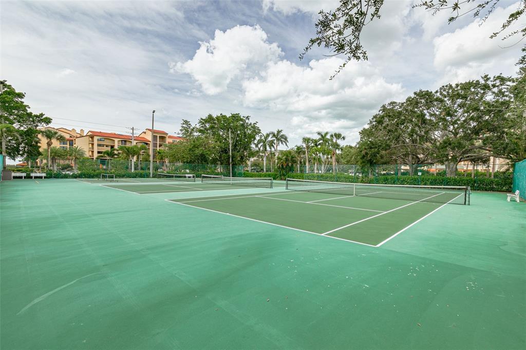 8701 Midnight Pass Road, Unit 106A Sarasota, FL 34242 - Photo 49 of 54 a view of a tennis ground with large trees