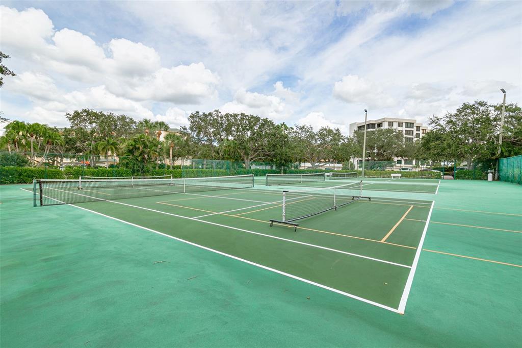 8701 Midnight Pass Road, Unit 106A Sarasota, FL 34242 - Photo 50 of 54 a view of a tennis ground with lots of trees