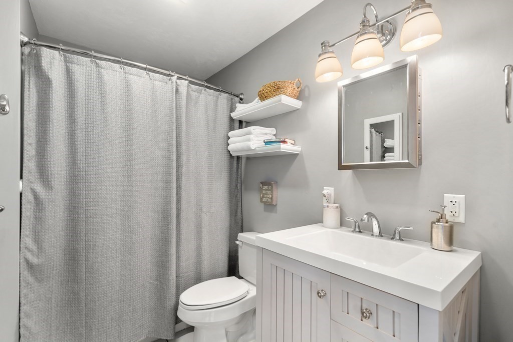 49 Woody Island Road Hopkinton, MA 01748 - Photo 14 of 33 a bathroom with a sink a toilet and shower curtain
