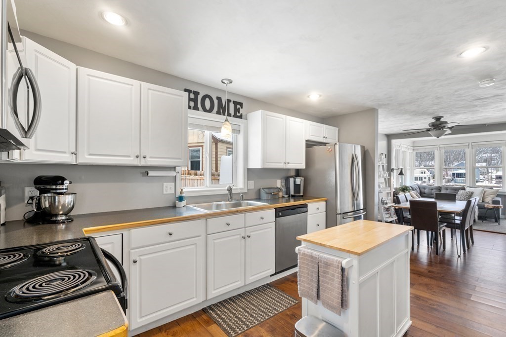 49 Woody Island Road Hopkinton, MA 01748 - Photo 4 of 33 a kitchen with a refrigerator a stove a sink dishwasher and white cabinets with wooden floor
