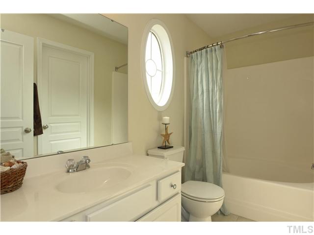 7660 Winners Edge Street Raleigh, NC 27617 - Photo 7 of 12 Long master bath with one piece marble vanity, nickel finish hardware, garden tub with extended round shower rod for max space, tile flooring, unique oval side window- only found in end unit plans. Addtl linen closet in hallway.
