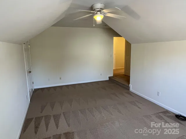 an empty room with a ceiling fan and a window