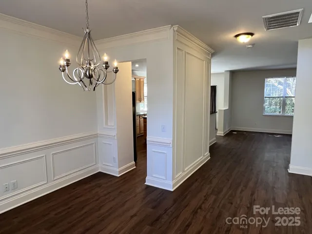 a view of a room with wooden floor staircase and a kitchen space