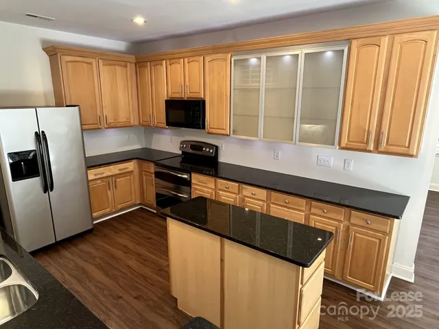 a kitchen with stainless steel appliances granite countertop a stove a sink and a microwave