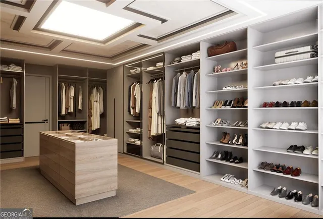 a view of walk in closet with clothes and shoes