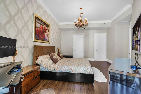 a bedroom with a bed and a chandelier