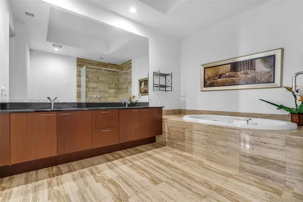 a spacious bathroom with stainless steel appliances a bathtub and a double vanity sink