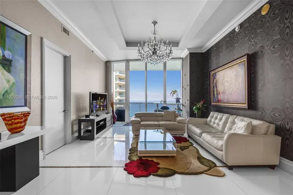 a living room with furniture chandelier and a window
