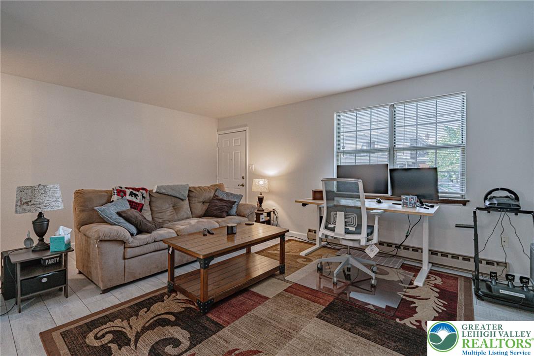 25 North 8th Street Emmaus, PA 18049 - Photo 7 of 51 A versatile living space offering comfortable lounging and a dedicated workspace with ample natural light.