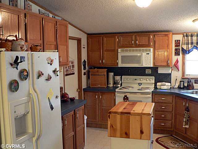 2374 Diggstown Road Bumpass, VA 23024 - Photo 4 of 10 a kitchen with stainless steel appliances granite countertop a refrigerator and a stove