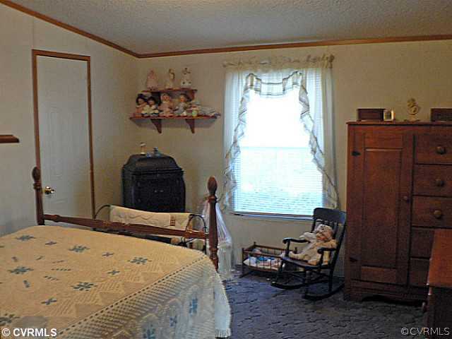 2374 Diggstown Road Bumpass, VA 23024 - Photo 8 of 10 a bedroom with a bed and wooden floor