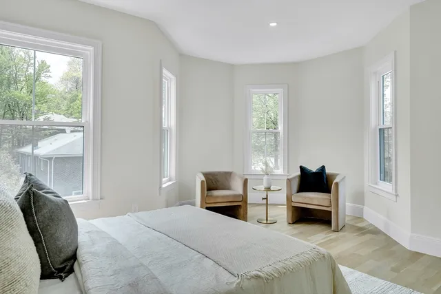 a bedroom with a bed a large window and couch