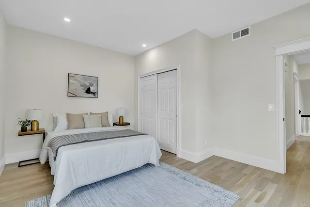 a bedroom with a bed and wooden floor