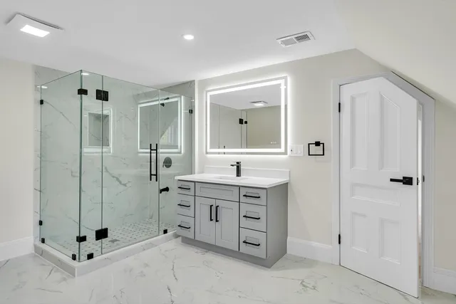 a spacious bathroom with a granite countertop sink mirror and shower