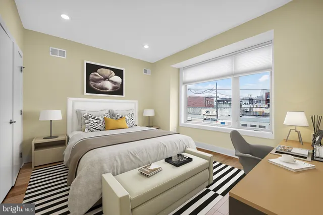 a bedroom with a bed and large window