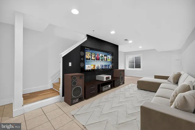 a living room with furniture a flat screen tv and a window