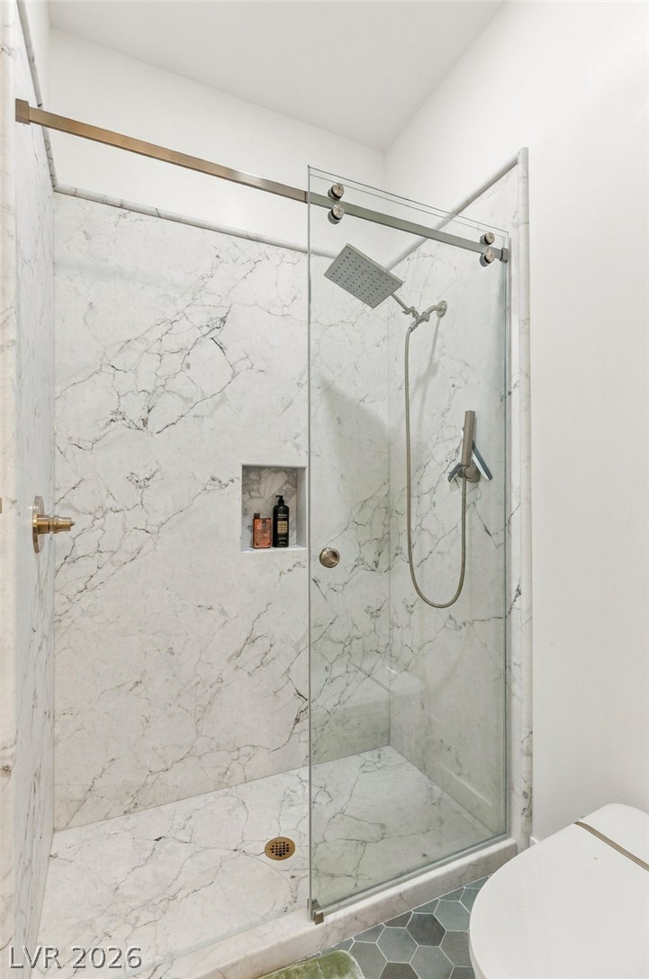 324 Wanda Road Henderson, NV 89002 - Photo 55 of 96 Floor-to-ceiling marble tile and sleek glass doors elevate this modern walk-in shower design.