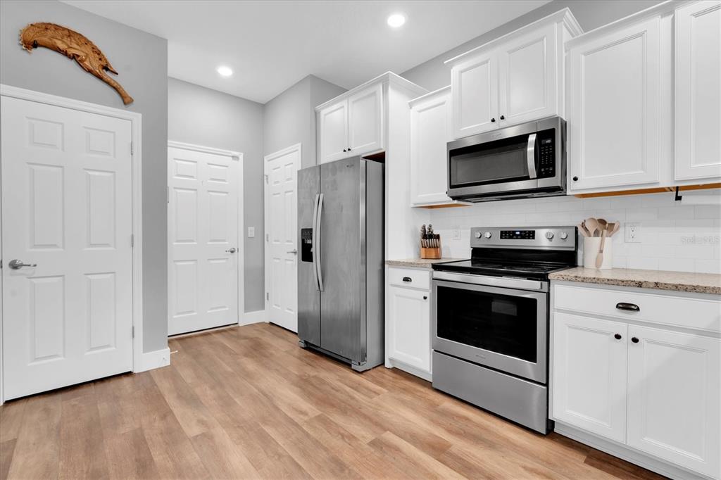 5233 Sylvester Loop Tampa, FL 33610 - Photo 11 of 36 a kitchen with stainless steel appliances white cabinets a sink and a microwave