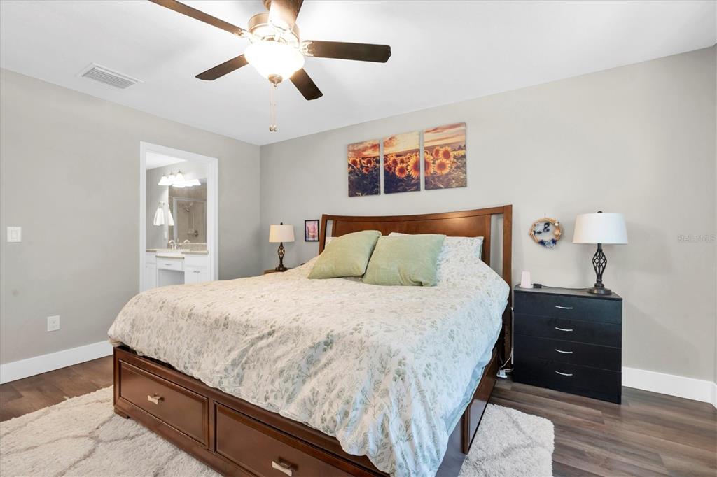 5233 Sylvester Loop Tampa, FL 33610 - Photo 16 of 36 a bedroom with a bed and a chandelier