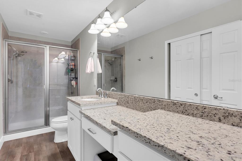 5233 Sylvester Loop Tampa, FL 33610 - Photo 17 of 36 a bathroom with a granite countertop sink a toilet and shower