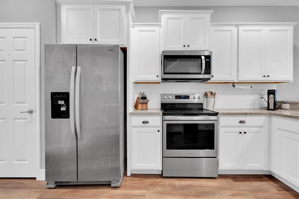 5233 Sylvester Loop Tampa, FL 33610 - Photo 10 of 36 a kitchen with stainless steel appliances a refrigerator stove and white cabinets