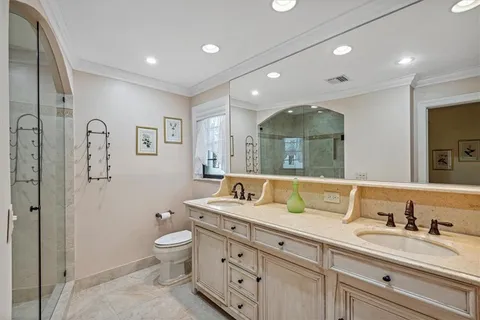 a bathroom with double vanity sink a mirror and a toilet