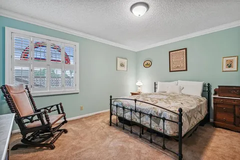a bedroom with a bed chair and a window
