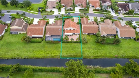 an aerial view of a house with a garden and lake view