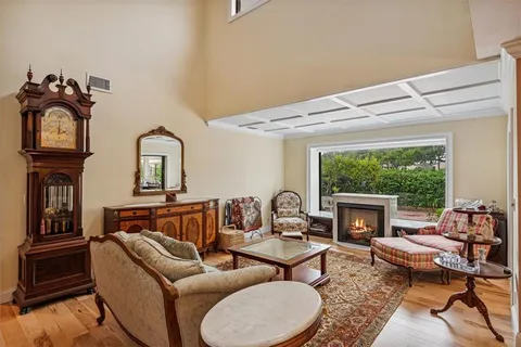 a living room with furniture fireplace and a large window